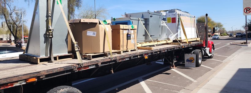 Flatbed truck loaded with new air conditioning units on a Phoenix street