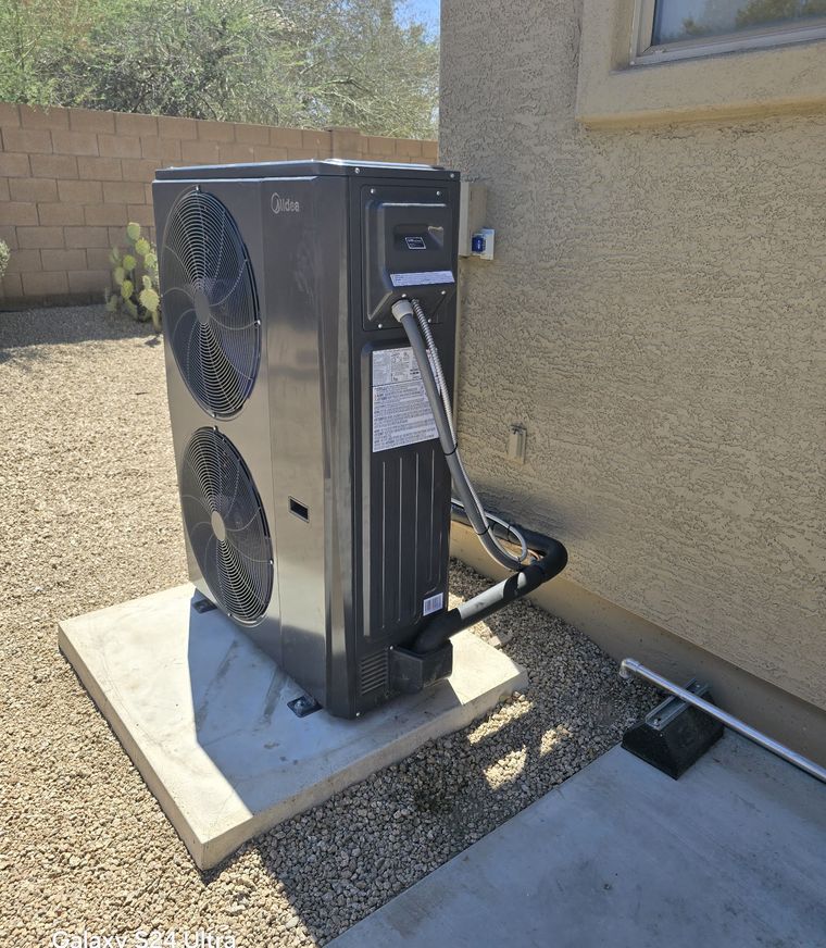 Outdoor heat pump unit installed on a concrete pad against a Peoria home